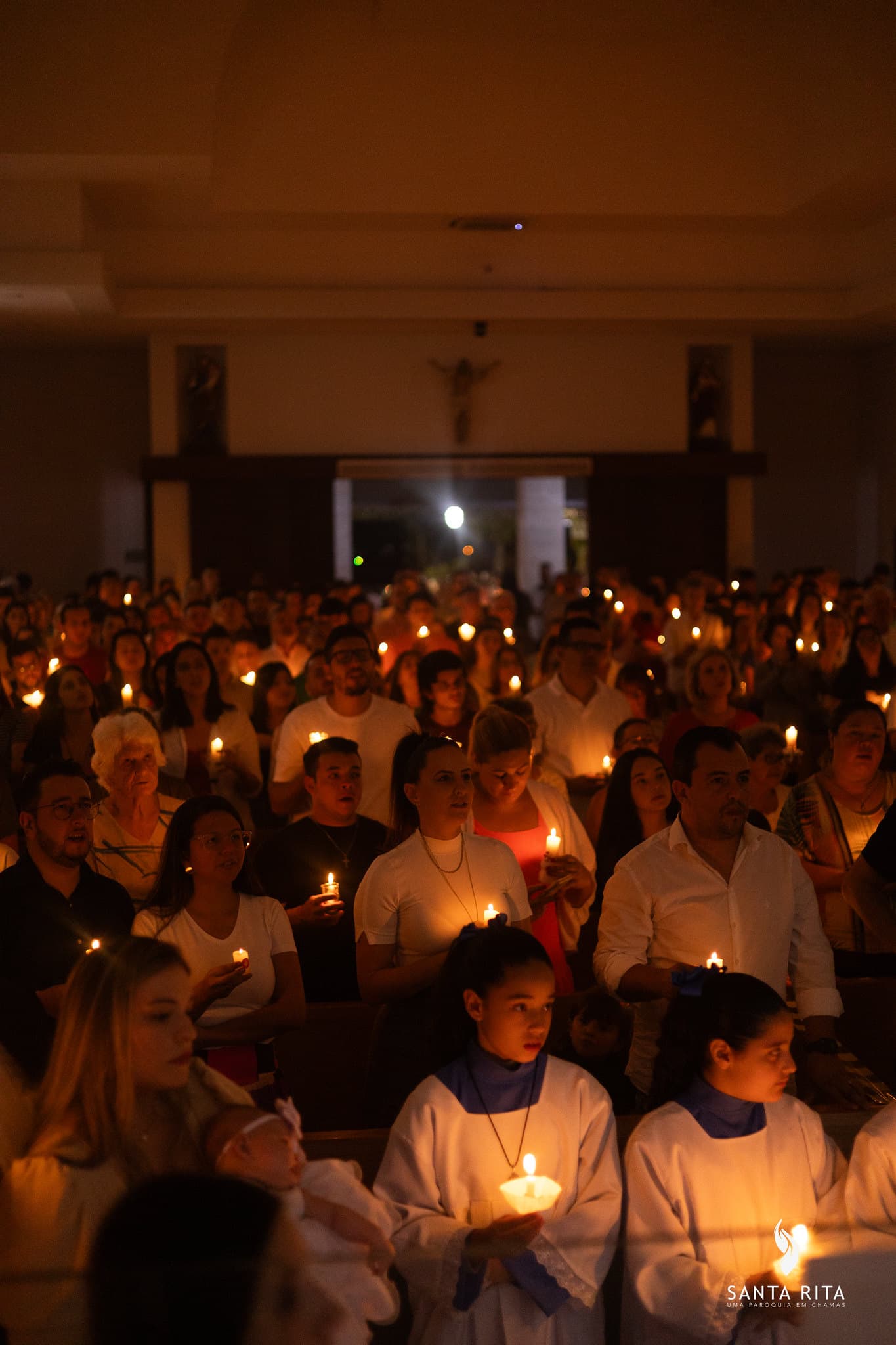 Fiéis com velas acesas na Matriz Santa Rita