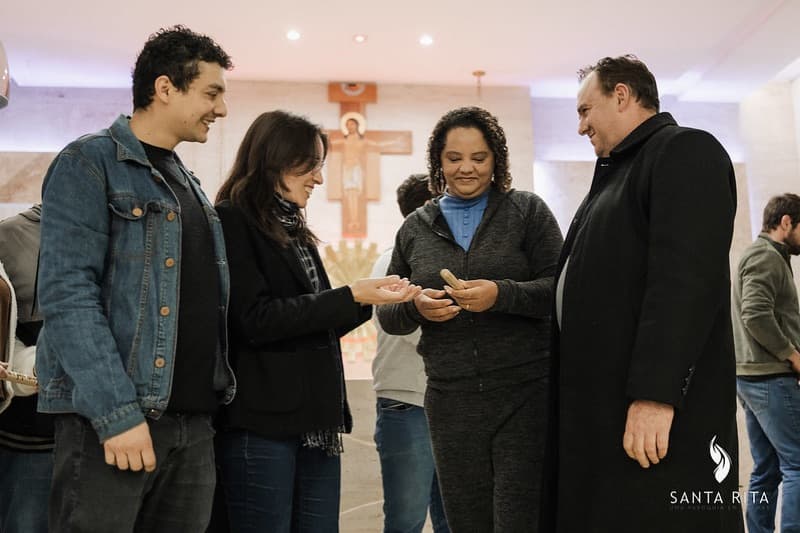 Integrantes de célula recebendo a bênção do padre