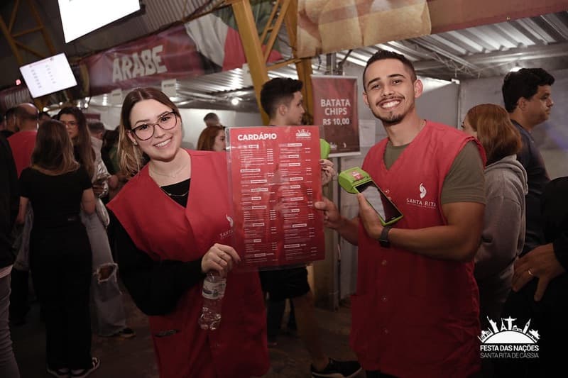 Voluntários com o cardápio de uma barraca da Festa das Nações